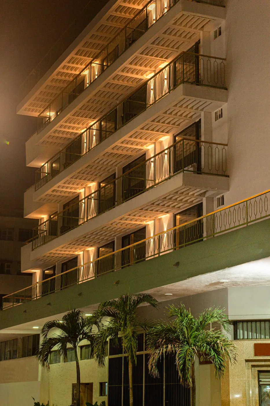 Fachada iluminada de Mood Matuna Hotel de noche, con palmeras