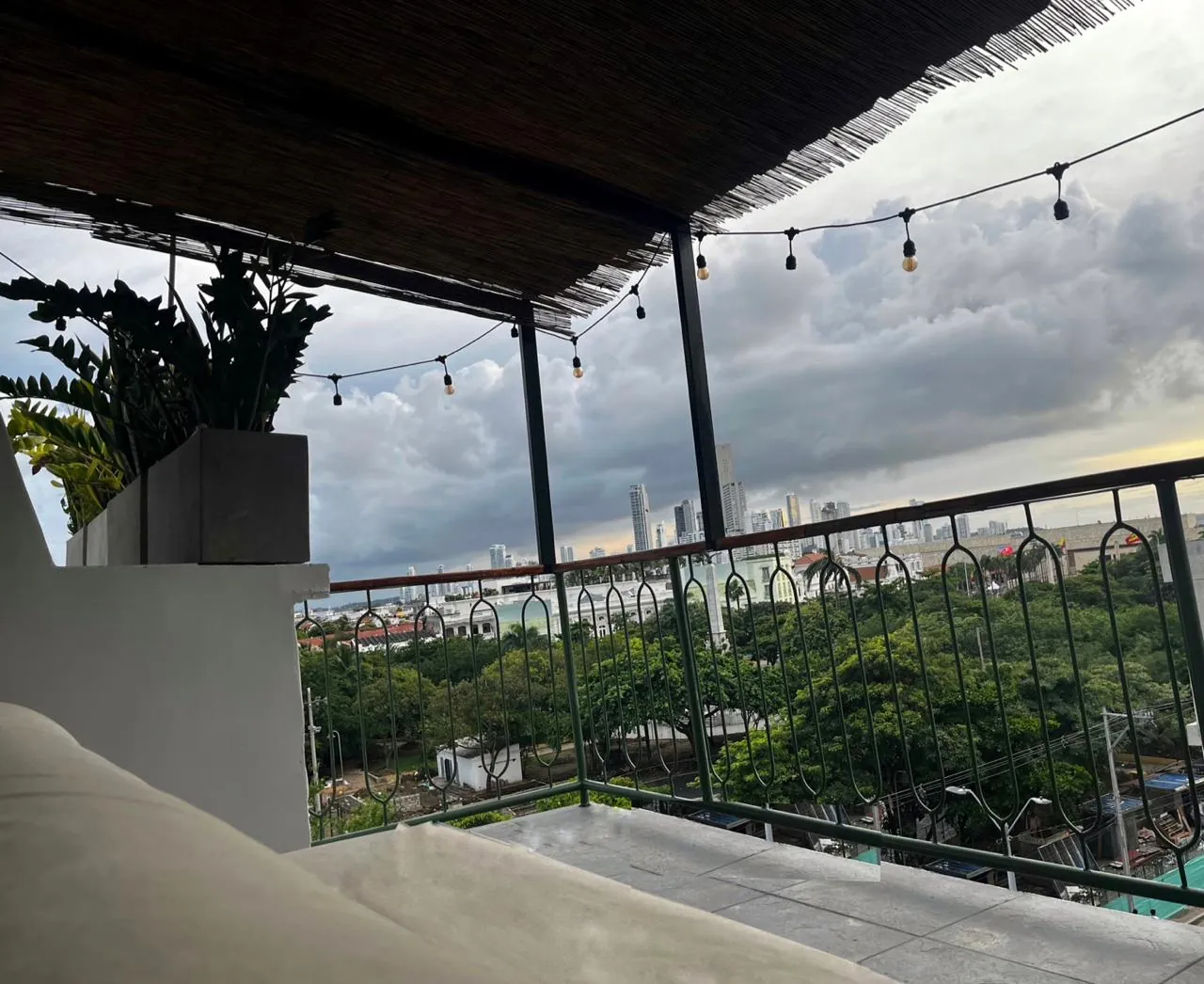 Balcón con vista a la ciudad, plantas y luces colgantes en Mood Matuna Hotel