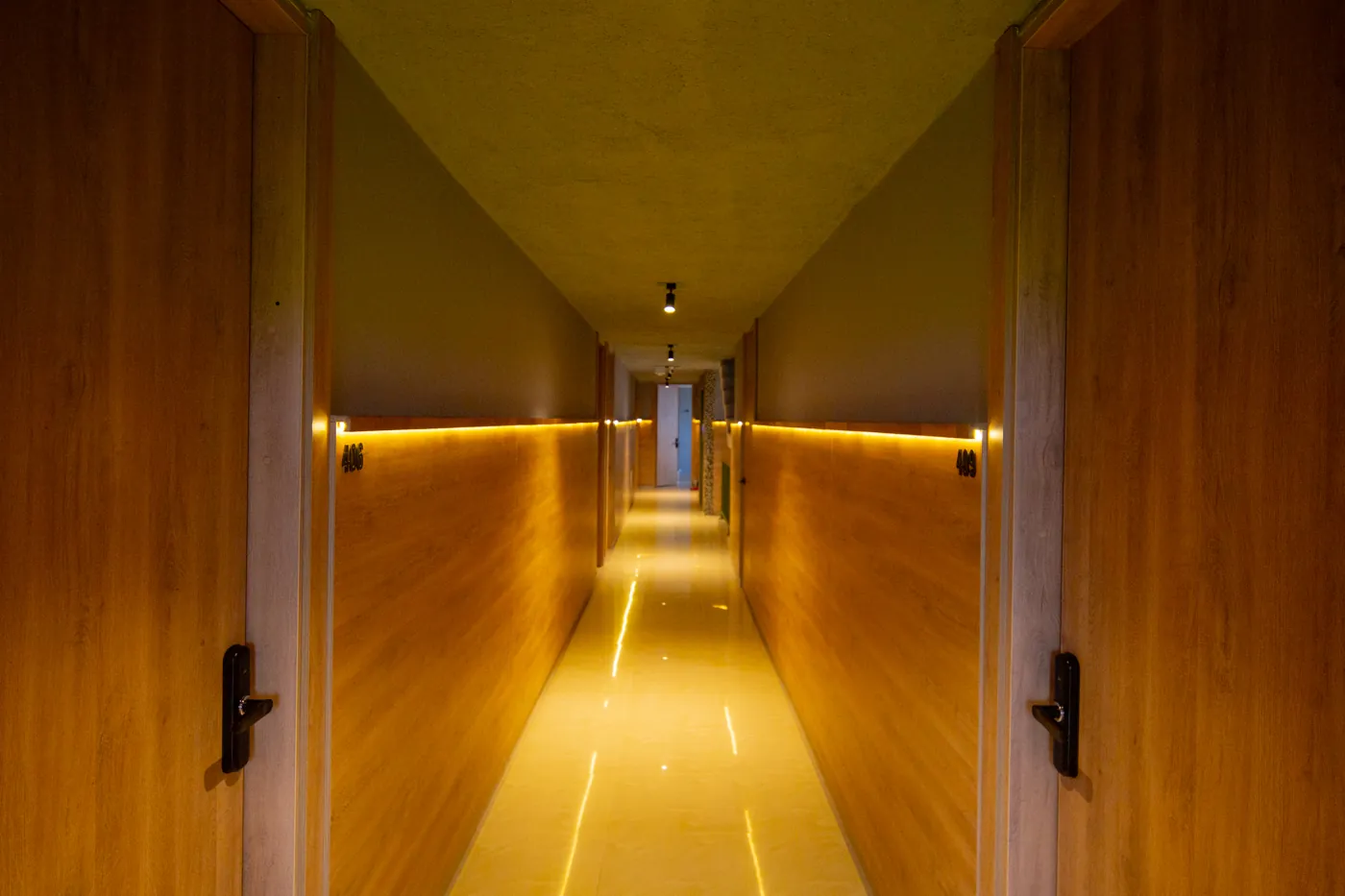 Corredor de Mood Matuna Hotel con paredes de madera y luz cálida indirecta